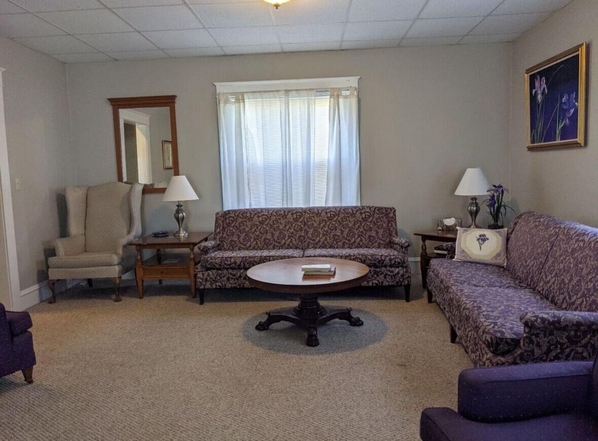 阿尔穆尼家的客厅里有两张沙发，两把椅子和带灯的小桌子.
